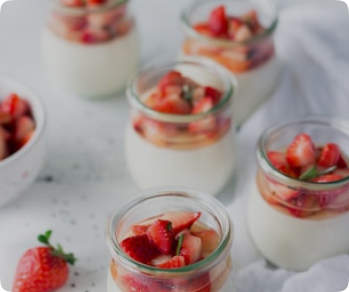 yogurt parfait with strawberries and sprigs of thyme in mason jars
