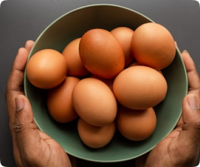 a person holding a bowl of eggs