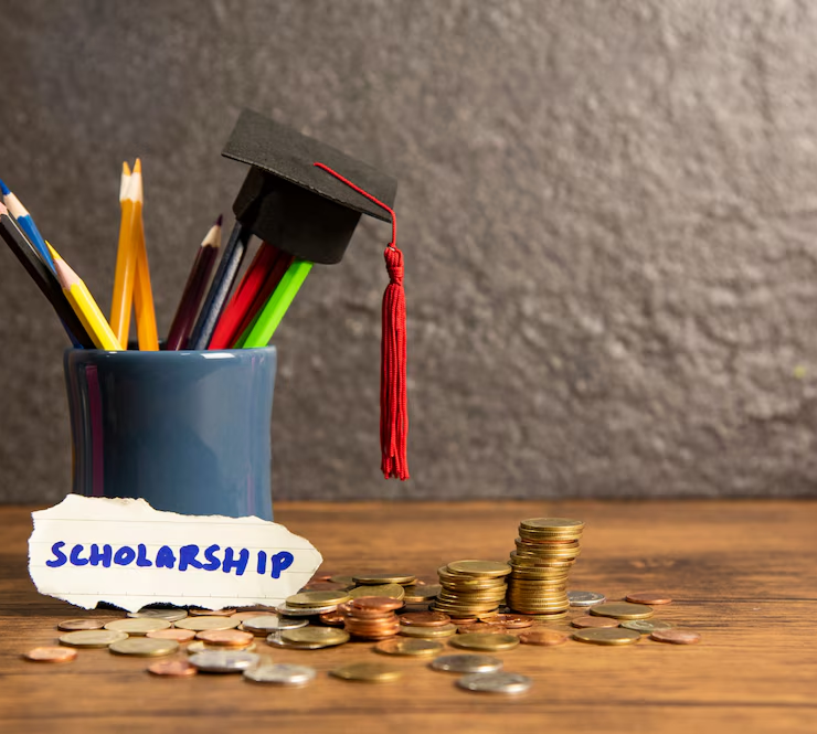 a cup of money and a hat with the word scholarship on it