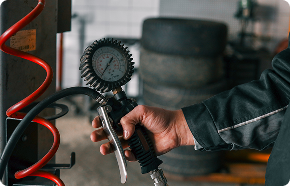 a man uses a tire gauge to check tire pressure