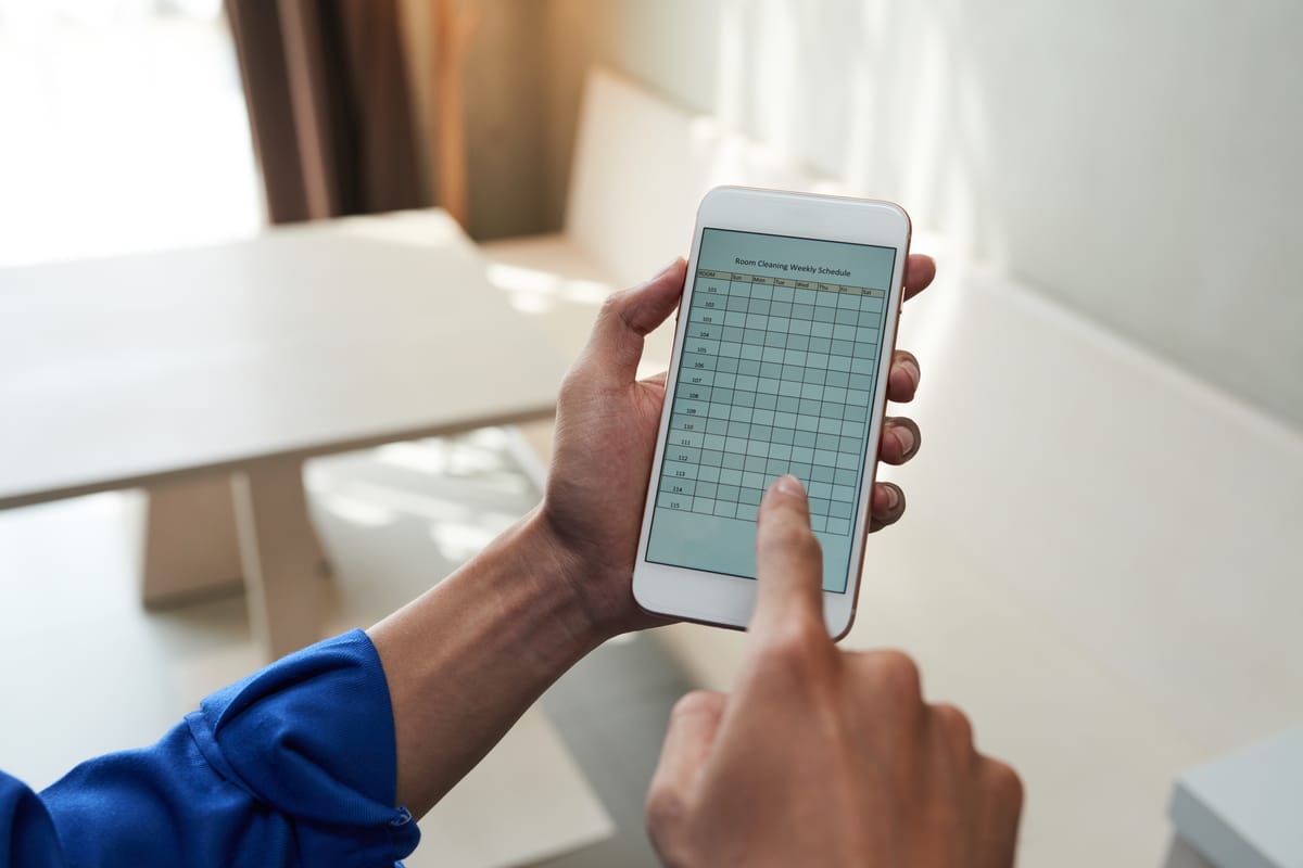 Hand holding a smartphone displaying a mobile punch list application.